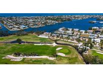 Gorgeous overhead view of waterfront homes on the golf course with stunning water views on a sunny day at 621 Ivanhoe Ln, Holmes Beach, FL 34217