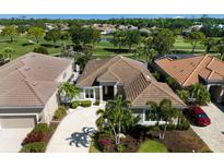 Stunning home featuring tile roof, lush landscaping, and golf course view at 8771 52Nd E Ave, Bradenton, FL 34211