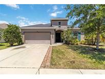 Charming single-Gathering home with a two-car garage, well-maintained lawn, and colorful landscaping at 10860 79Th E St, Parrish, FL 34219