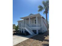 Charming two-story home with elevated porch, white railings, and new landscaping at 14343 Myakka Ave, Port Charlotte, FL 33953