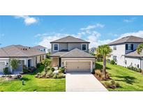 Beautiful two-story home with a well-manicured lawn and attractive landscaping at 16119 Paynes Mill Dr, Bradenton, FL 34211