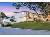 Two-story home featuring a large front yard, landscaping, and two-car garage at 2111 Ivory Pl, Sarasota, FL 34239