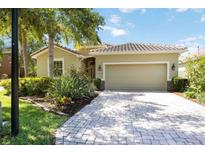 Charming home featuring a tile roof, two car garage, paved driveway and lush landscaping at 2239 Ellarose Cir, Sarasota, FL 34232