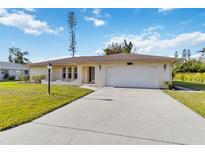 Charming single story home featuring an attached two car garage and a well manicured lawn at 2271 Pine View Cir, Sarasota, FL 34231
