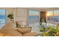 Living room with ocean view at sunset, offering a relaxing ambiance enhanced by natural light and modern decor at 2525 Gulf Of Mexico Dr # 3F, Longboat Key, FL 34228