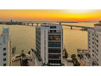 Stunning aerial view of a modern high-rise building near the water and a beautiful sunset at 280 Golden Gate Pt # 600, Sarasota, FL 34236