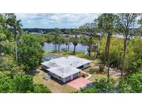 Expansive aerial view of a home with a pool, lush landscaping, and waterfront access at 4311 52Nd E St, Bradenton, FL 34208