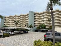 Multi-story condo building exterior featuring parking under building and several outdoor balconies at 5780 Midnight Pass Rd # 410, Sarasota, FL 34242