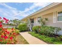Beautifully landscaped front yard with colorful flowers and view of the water at 623 Estuary Dr, Bradenton, FL 34209