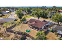 Aerial view of backyard with screened-in porch, fenced yard, and green fire pit at 6547 Samoa Dr, Sarasota, FL 34241