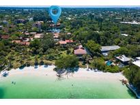 Beautiful aerial view of beachfront homes, white sand, and clear turquoise water at 7 Sandy Cove Rd, Sarasota, FL 34242