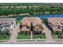 Beautiful aerial view of a multi-Gathering home with lake view and paved driveway at 7425 Divot Loop, Lakewood Ranch, FL 34202