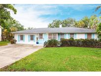 Charming single-story home featuring light blue shutters, a well-manicured lawn, and a concrete driveway at 104 Shoreland Dr, Osprey, FL 34229