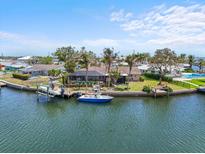 Waterfront property with private dock, boat, palm trees and screened-in pool, perfect for enjoying the coastal lifestyle at 10432 Sandpiper W Rd, Bradenton, FL 34209