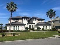 Beautiful two-story home featuring a well-manicured lawn and lush landscaping with lovely palm trees at 1109 Riverscape St, Bradenton, FL 34208