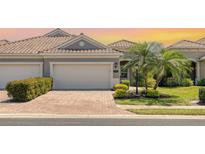 Charming home featuring a brick driveway, two-car garage and a well-manicured lawn with mature landscaping at 1203 Calle Grand St, Bradenton, FL 34209