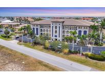 Stunning exterior view of a multi-story building with meticulous landscaping and architectural details at 1349 Aqui Esta Dr # 143, Punta Gorda, FL 33950