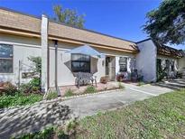 Charming villa with a quaint front patio, complete with seating and a lovely garden area, set on a sunny day at 1526 Mission Hills Blvd # 18B, Clearwater, FL 33759