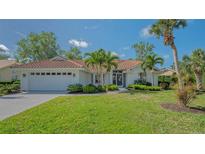 Charming single-story home featuring a red tile roof, lush landscaping, and a well-manicured lawn at 2115 Timucua Trl, Nokomis, FL 34275