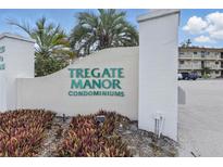 Well-maintained Tregate Manor Condominiums community sign with vibrant greenery and tropical palm trees at 2220 Stickney Point Rd # 531, Sarasota, FL 34231