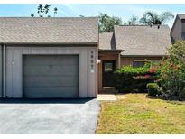 Charming townhome featuring an attached garage, well-maintained landscaping, and inviting front entrance at 5657 Westwind Ln, Sarasota, FL 34231
