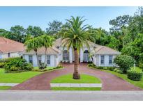 Stunning single-story home featuring a beautiful circular driveway and lush tropical landscaping at 6620 Saint James Xing, University Park, FL 34201