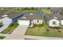 Charming single-Gathering home with a well-manicured lawn, lush landscaping, a two-car garage, and a pond view at 9725 Last Light Gln, Parrish, FL 34219