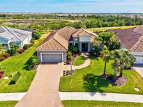 Beautiful home featuring a paver driveway, tile roof, two-car garage, and well-manicured landscaping at 10816 O Meara Way, Englewood, FL 34223
