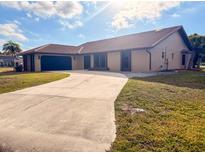 Charming single-story home with well-kept lawn, mature trees, and a private two-car garage at 1438 Vermouth Ln, Punta Gorda, FL 33983