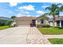 Charming single-story home featuring a two-car garage, well-maintained lawn, and a beautiful palm tree at 1717 Bonita Bluff Ct, Ruskin, FL 33570