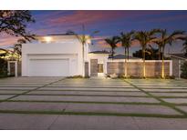 Stunning modern home featuring a well-manicured lawn, sleek design, and a beautiful sunset backdrop at 238 Island Cir, Sarasota, FL 34242