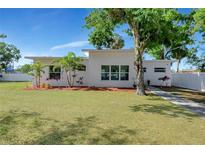 Modern home boasts a well-manicured lawn, elegant landscaping, and a white exterior with expansive windows at 3090 6Th St, Sarasota, FL 34237