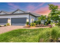 Charming single-story home features a well-manicured lawn, lush landscaping, and a paved walkway to the front entrance at 4750 Tortona Ct, Bradenton, FL 34211