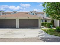 Townhouse featuring an attached garage, well-maintained landscaping, and a charming exterior at 5346 Neil Dr, St Petersburg, FL 33714