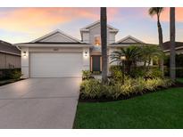Charming two-story home boasts a well-manicured lawn, lush landscaping, and a spacious two-car garage at 6523 Blue Grosbeak Cir, Lakewood Ranch, FL 34202