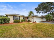 Charming single-story home with well-maintained landscaping, mature trees, and an attached two-car garage at 7391 W Country Club N Dr, Sarasota, FL 34243