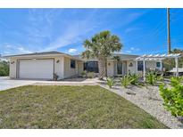 Charming single-story home with a well-manicured lawn and inviting front entrance, featuring a two-car garage at 801 E 5Th St, Englewood, FL 34223