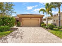Charming single-story home featuring a paver driveway, a neutral palette and a well-maintained lawn at 11959 Tapestry Ln, Venice, FL 34293