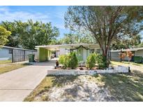 Charming one-story home featuring a carport, front garden, and a light-green exterior in a tranquil neighborhood at 1417 14Th E St, Bradenton, FL 34208