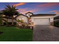 Charming single-Gathering home featuring a lush front yard, stone accents, and a two-car garage at 17418 Blue Ridge Pl, Lakewood Ranch, FL 34211