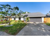 Charming single-story home with a well-manicured lawn, vibrant landscaping, and a concrete driveway at 2005 38Th W St, Bradenton, FL 34205