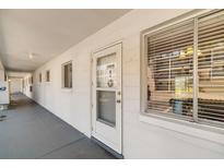 Condo entrance with secure door, nearby mailbox, and large window for natural lighting at 2008 Canal Dr # M3, Bradenton, FL 34207