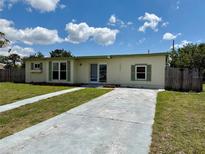 Charming single-story home featuring a well-maintained lawn and a long concrete driveway under a sunny sky at 22343 Lasalle Rd, Port Charlotte, FL 33952