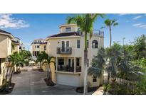 Beige three-story home featuring multiple balconies and a rooftop deck, surrounded by lush palm trees at 436 Canal Rd # A, Sarasota, FL 34242