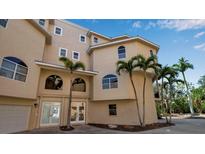 Exterior corner view of a beige three-story home showing the entrance and multiple arched windows at 436 Canal Rd # A, Sarasota, FL 34242