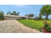 Charming single-story home featuring a well-manicured lawn and brick paved driveway at 4861 Waterbridge Down, Sarasota, FL 34235
