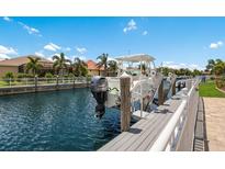 Waterfront property featuring a boat on a lift with access to beautiful canal and homes at 569 Mast Dr, Bradenton, FL 34208