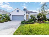 Charming single-story home with a well-manicured lawn and a two-car gray garage door at 7526 Ridgelake Cir, Bradenton, FL 34203