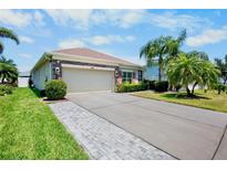 Charming home features a two-car garage, beautiful landscaping, and a well-manicured lawn at 9052 41St E St, Parrish, FL 34219