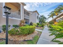 Beautiful condo exterior with lush landscaping, screened in porch, and walkway on a sunny day at 9560 High Gate Dr # 1622, Sarasota, FL 34238